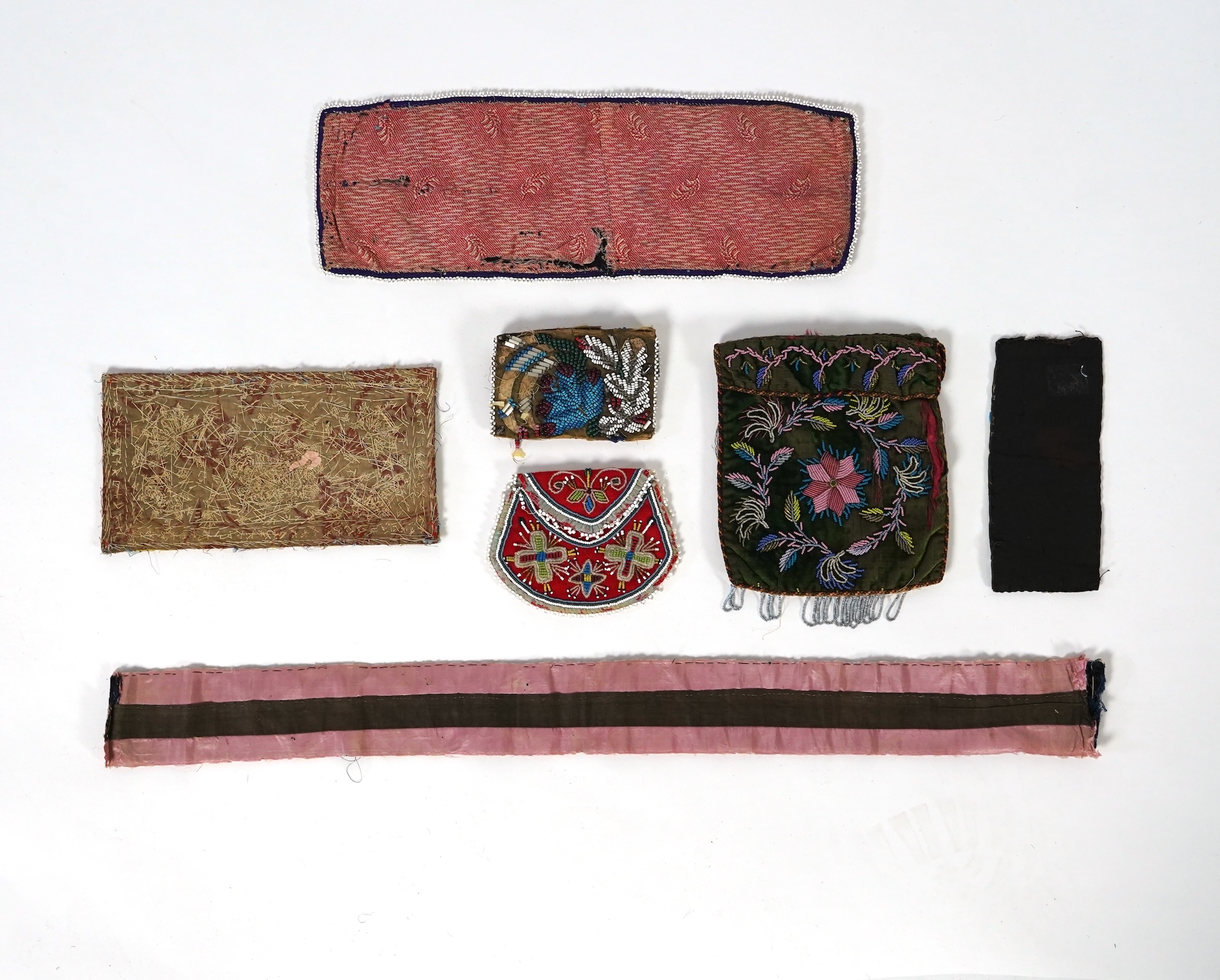 A 19th century black felt multi coloured beadwork panel, possibly North American Indian and a similar purse, a Regency fine bead worked bible bag, a similar worked belt and small panel, a red bead work purse and a small